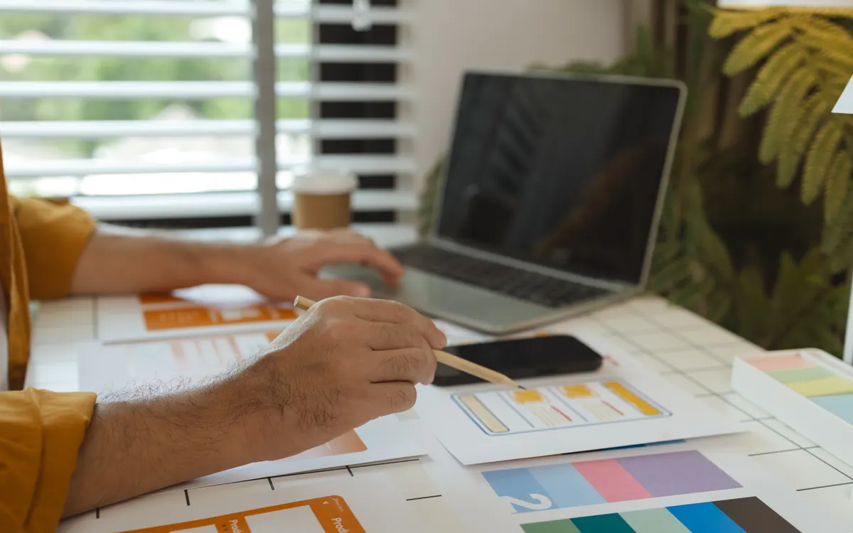 Bocetos de marca y paletas de color sobre la mesa de trabajo