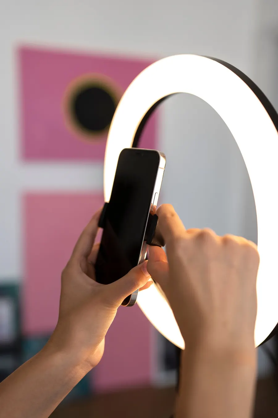 Content creator setting her phone on a ring light to record
